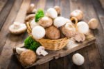 Egerlinge und weiße Champignons im Korb