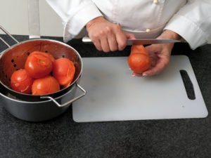 Tomate mit dem Meser schälen