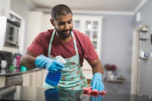 ein mann beim reinigen der kuechenarbeitsplatte aus marmor