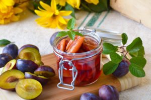 Obst in einem Glas, daneben andere Früchte und Blumen dekoriert