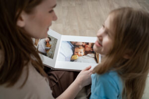 Mutter und Tochter sehen sich ein Fotobuch mit Familienbildern an.