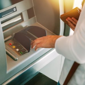 frau hebt geld am automaten ab