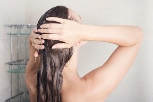 Frau wäscht Haare nur mit Wasser.