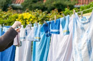 frau haengt handtuecher an der waescheleine auf