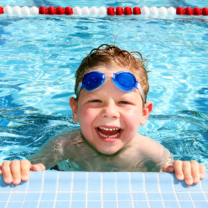 froehlicher junge im schwimmbecken