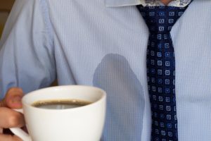 mann mit einem kaffeefleck auf seinem hemd