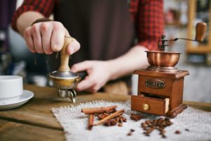 ein barista mit einer kaffeemuehle