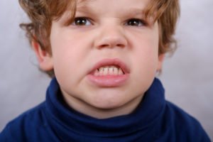 Kind zeigt wütend die Zähne