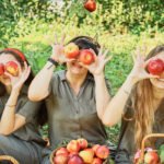Kinder spielen mit Äpfeln von Apfelbaum