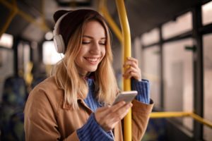 eine junge frau mit kopfhoerern im bus