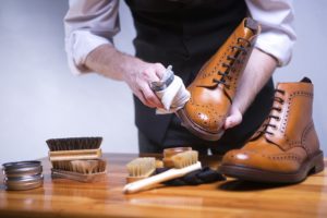 ein mann pflegt seine lederschuhe