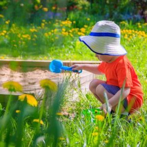 kind in sandkasten im garten