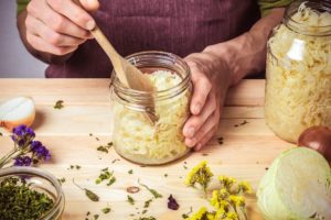 ein mann macht sauerkraut in einem glas selbst