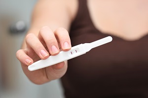 Frau mit Schwangerschaftstest.