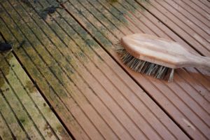 eine buerste auf eine halb gesaeuberten holzterrasse