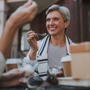 frau mit zahnprothese isst eis